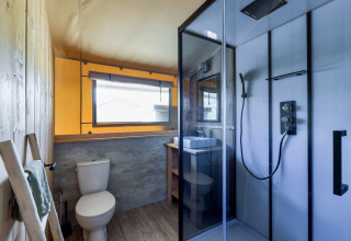 Modernes Badezimmer im Safarilodge Gazelle, Vakantiepark IJsselhof, mit Dusche, WC und Waschbecken.
