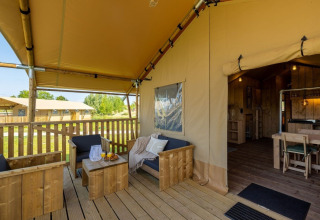 Veranda coperta in legno alla Safarilodge Gazelle, Vakantiepark IJsselhof, Olanda, con area relax.