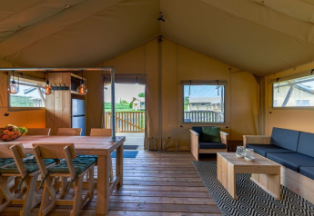 Interno della lussuosa tenda safari Safarilodge Gazelle con arredi in legno al Vakantiepark IJsselhof, Paesi Bassi.