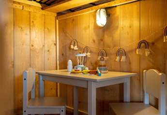 Angolo bambini nella Safarilodge Gazelle al Vakantiepark IJsselhof con giocattoli e arredamento in legno.