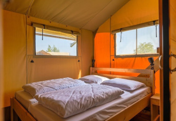 Indretning i Safarilodge Gazelle safari-telt med dobbeltseng og vinduer på Vakantiepark IJsselhof, Holland.