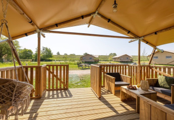 View from the porch of Safarilodge Impala at Vakantiepark IJsselhof in the Netherlands with seating area.