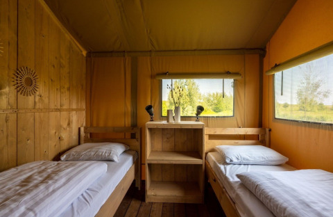 Interior de la tienda safari Safarilodge Impala con dos camas individuales en Vakantiepark IJsselhof, Países Bajos.