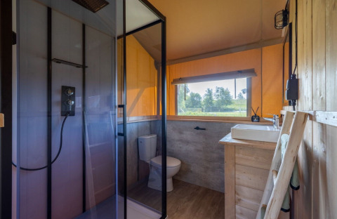 Bagno moderno nella Safarilodge Impala al Vakantiepark IJsselhof, con doccia, WC e vista sulla natura.