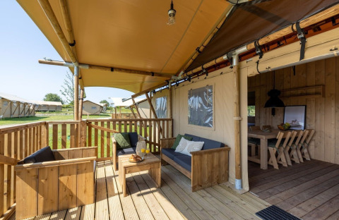 Udendørs terrasse af Safarilodge Impala på Vakantiepark IJsselhof i Holland med træmøbler og afslapning.