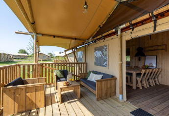 Überdachte Terrasse der Safarilodge Impala im Ferienpark IJsselhof in den Niederlanden mit Sitzbereich.