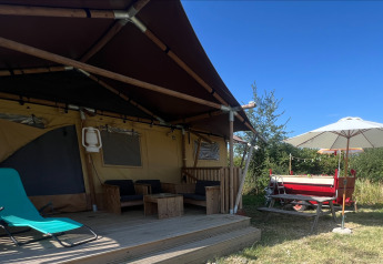 Tente safari glamping avec terrasse en bois, transat et parasol chez Per Amore del Vino en Italie.
