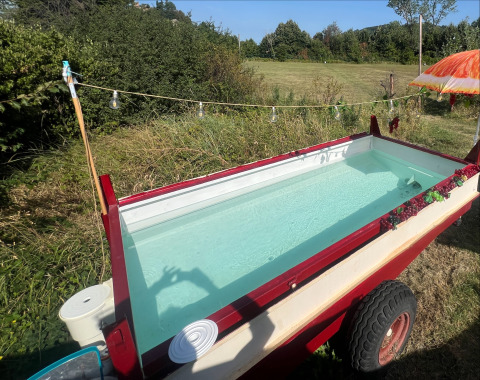 Ataúd al aire libre convertido en mini piscina junto a la tienda Glamping en Per Amore del Vino, Italia, verano.