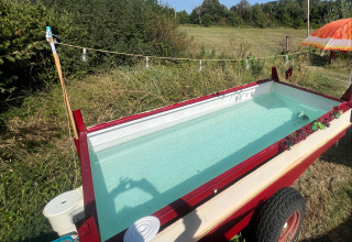 Ataúd al aire libre convertido en mini piscina junto a la tienda Glamping en Per Amore del Vino, Italia, verano.