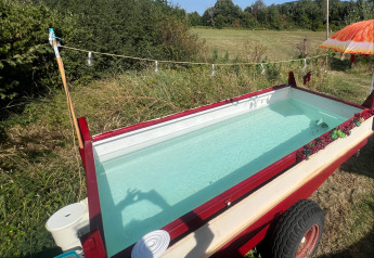 Cercueil transformé en mini-piscine près d'une tente glamping à Per Amore del Vino, Italie, en été.