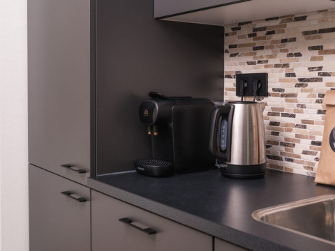 Moderne kitchenette met waterkoker en koffiemachine in Loevestein Deluxe, Veluwepark de Bosgraaf, Nederland.