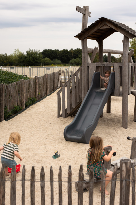 Kinderen spelen op een speelplaats met glijbaan en zand bij Feather Down Het Keelven, Noord-Brabant.