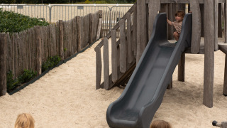 Kinderen spelen op een speelplaats met glijbaan en zand bij Feather Down Het Keelven, Noord-Brabant.