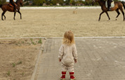 A small child watches two horseback riders; a highlight of Feather Down Het Keelven holiday park in the Netherlands.