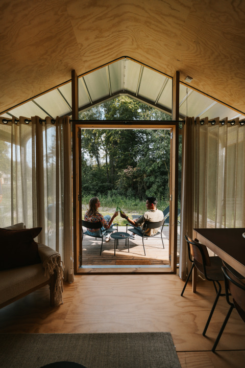 Binnenzicht van Wrap house bij Resort de Parel, met twee personen rustig buiten op het terras.