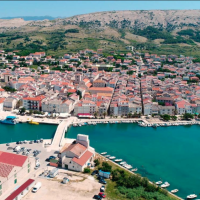 Vista aerea di Povljana, contea di Zadar, Croazia, con case dai tetti rossi e porto turistico.