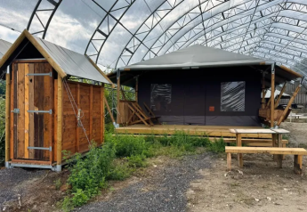 Tenda safari con doccia privata in legno e panca all'aperto a Feather Down Ecuries de Gapennes, Francia.
