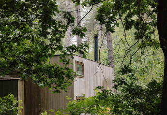 Cabina Classic di Cosy Cabins immersa tra gli alberi nella foresta di Limburg, Belgio.