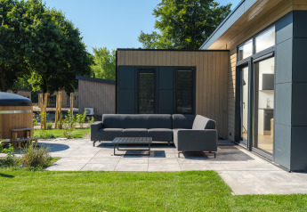 Moderner Terrassenbereich mit Sofa und Tisch bei Essenburgh Deluxe mit Whirlpool im Veluwepark de Bosgraaf.