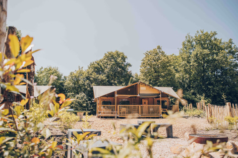 De Ranger Lodge safaritent frontaal gefotografeerd, omringd door bomen en natuur op een zonnige dag.