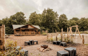 Safari-Zelt Ranger Lodge im Veluwepark de Bosgraaf mit Feuerstelle und Spielplatz in den Niederlanden.