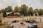 Tente safari Ranger Lodge à Veluwepark de Bosgraaf avec espace feu de camp et aire de jeux aux Pays-Bas.