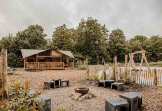 Safari-Zelt Ranger Lodge im Veluwepark de Bosgraaf mit Feuerstelle und Spielplatz in den Niederlanden.