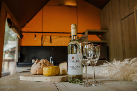 Vino, queso y pan sobre una mesa en una tienda safari en Ranger Lodge, Veluwepark de Bosgraaf, Países Bajos.