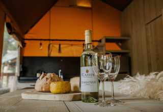 Wein, Käse und Brot auf einem Tisch in einem Safari-Zelt der Ranger Lodge, Veluwepark de Bosgraaf, Niederlande.