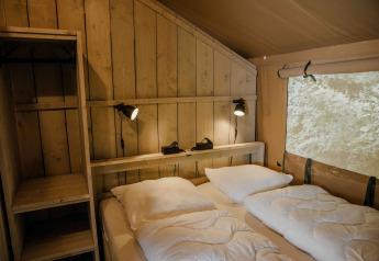 Interno camera da letto della tenda safari Ranger Lodge al Veluwepark de Bosgraaf, Paesi Bassi, stile rustico.