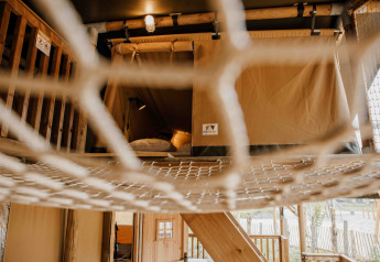 Vista interior de la tienda safari Ranger Lodge con suelo de red en Veluwepark de Bosgraaf, Países Bajos.