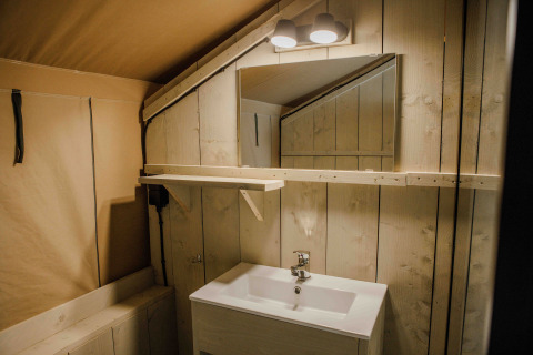 Badkamer in de Ranger Lodge safaritent in Veluwepark de Bosgraaf, Nederland, met houten bekleding.