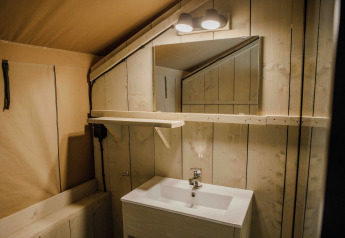 Bathroom in the Ranger Lodge safari tent at Veluwepark de Bosgraaf, Netherlands, featuring wood panels.