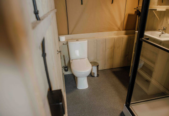 Salle de bain dans une tente safari Ranger Lodge à Veluwepark de Bosgraaf, Pays-Bas, avec équipements modernes.