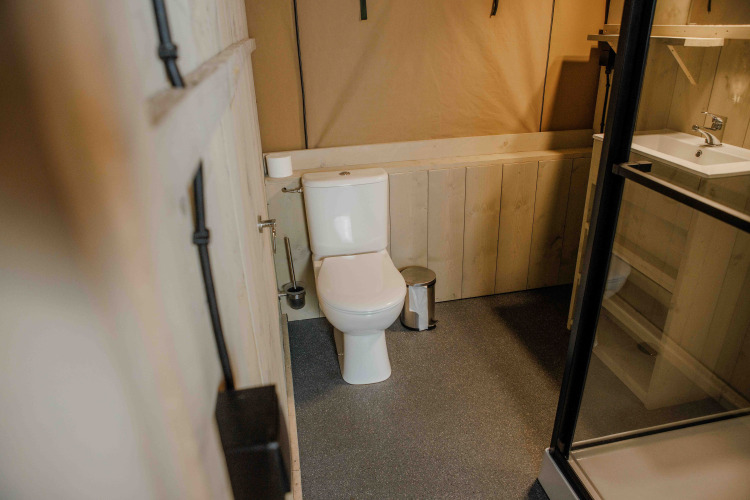 Badezimmer im Ranger Lodge Safari-Zelt im Veluwepark de Bosgraaf in den Niederlanden mit moderner Ausstattung.