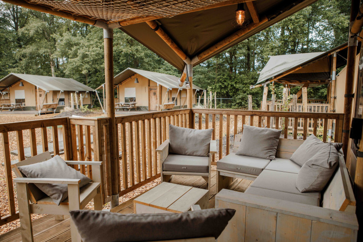 Terrasse mit gemütlichen Sitzplätzen im Ranger Lodge Safarizelt im Veluwepark de Bosgraaf, Niederlande.