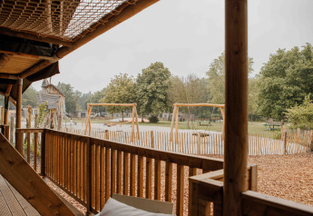 Udsigt fra Ranger Lodge safari-telt over legeplads og grønt område i Veluwepark de Bosgraaf, Holland.
