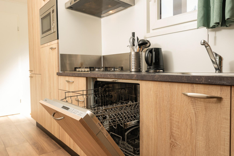 Moderne Küche in der Veluwe Lodge, Veluwepark de Bosgraaf, Niederlande mit offener Spülmaschine.