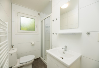 Bagno moderno alla Veluwe Lodge di Veluwepark de Bosgraaf, Paesi Bassi, con doccia e piastrelle bianche.