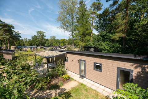 Forest Lodge au Veluwepark de Bosgraaf aux Pays-Bas, entouré de verdure et de forêts luxuriantes en été.