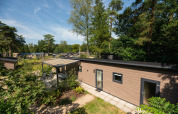 Forest Lodge ved Veluwepark de Bosgraaf i Holland, omgivet af grønne træer og smuk natur om sommeren.