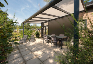 Terrasse extérieure au Forest Lodge du Veluwe park de Bosgraaf, Pays-Bas, avec chaises, table et transats