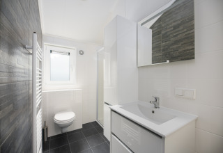 Moderne badkamer bij Loevestein-lodge in Veluwepark de Bosgraaf, Nederland, met een wit en stijlvol design.