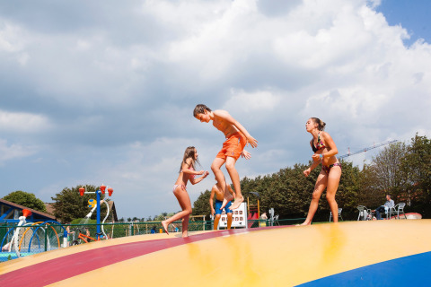 Kinderen spelen en springen op een kleurrijk luchtkussen bij Kompas Camping Nieuwpoort in West-Vlaanderen.