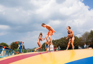 Kinderen spelen en springen op een kleurrijk luchtkussen bij Kompas Camping Nieuwpoort in West-Vlaanderen.