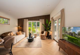 Salón de lodge moderno con muebles elegantes, pared de madera, grandes ventanas y vistas al exterior.