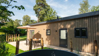 Buitenfoto van Loevestein-lodge met hot tub en terras in Veluwepark de Bosgraaf, Nederland.