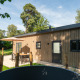 Outdoor photo of Loevestein lodge with hot tub and patio at Veluwepark de Bosgraaf in the Netherlands.