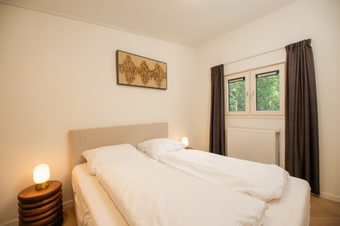 Modernes Schlafzimmer im Loevestein mit Whirlpool im Veluwepark de Bosgraaf, Niederlande, mit Doppelbett.