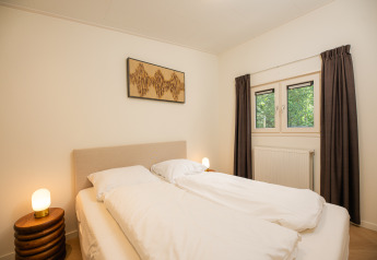 Modernes Schlafzimmer im Loevestein mit Whirlpool im Veluwepark de Bosgraaf, Niederlande, mit Doppelbett.